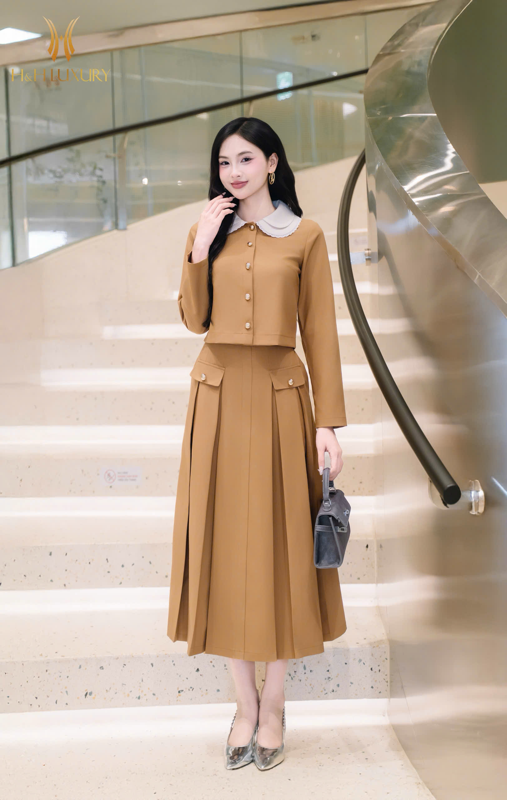 CHÂN VÁY XẾP LY NÂU BÒ ĐÍNH CÚC